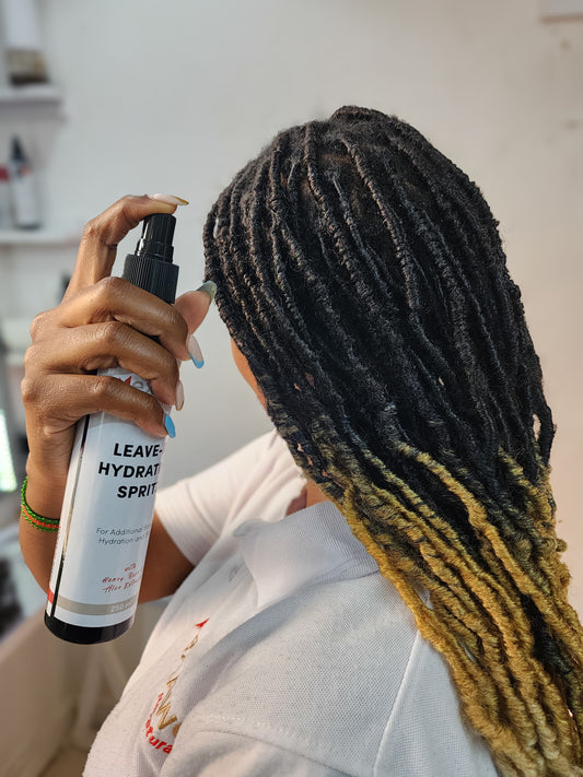 A lady moisturizing her scalp & locs using NextAwe Leave-in  Hydrating Spritz